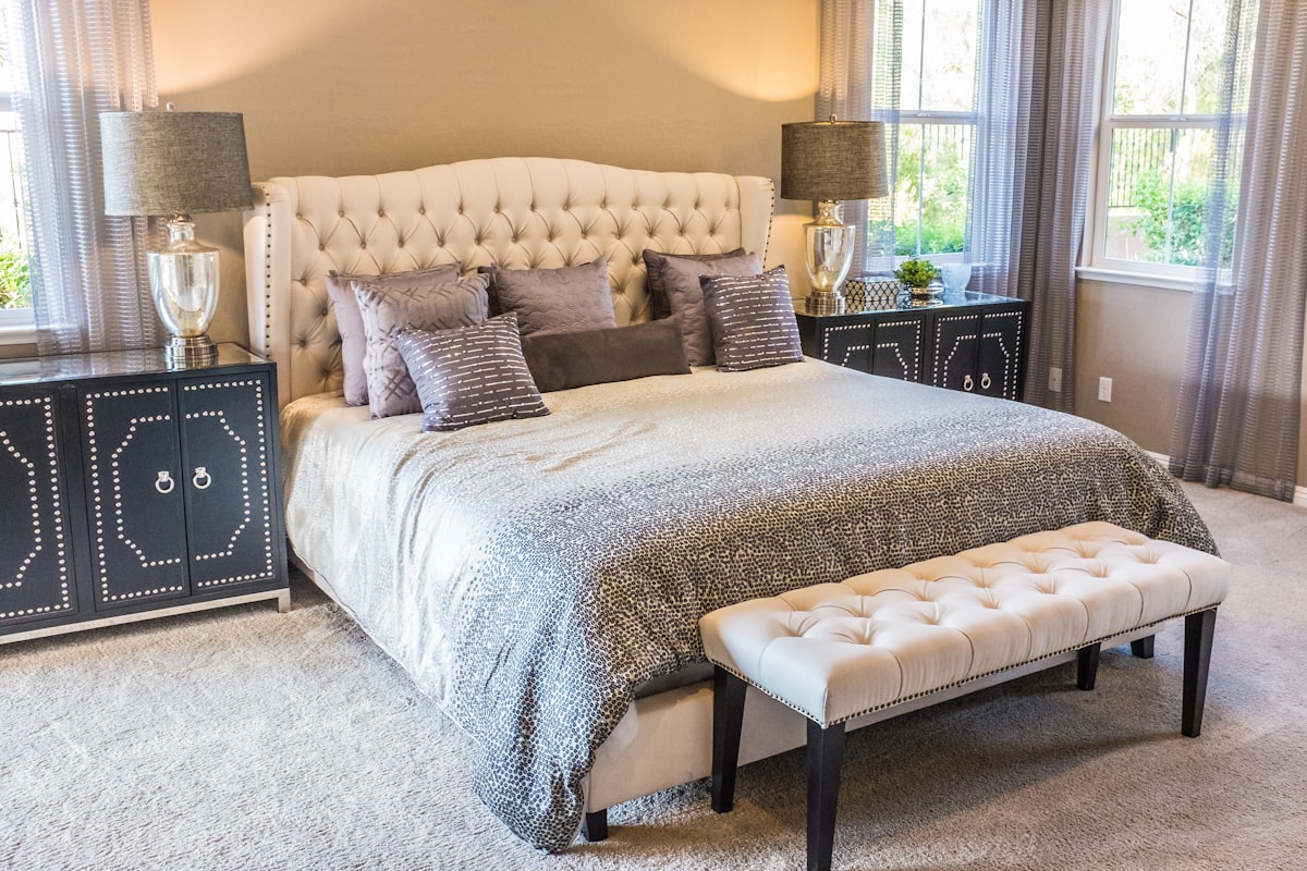 A pillow on a bed in a softly lit bedroom, ready for sleep